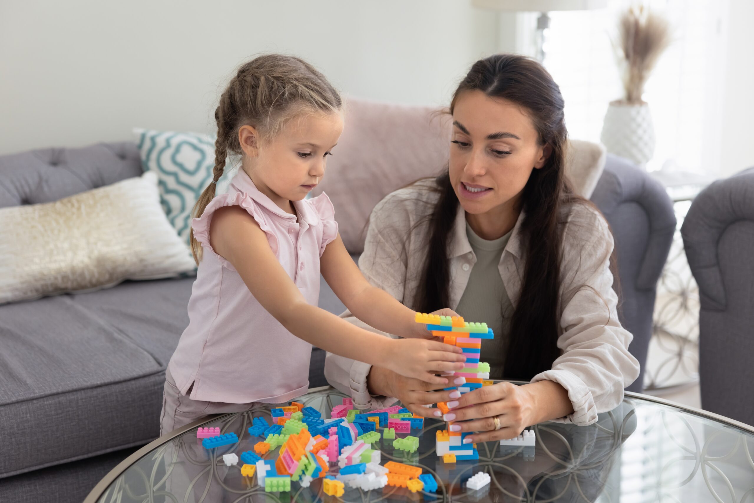 Serious,Caring,Young,Mother,Training,Preschooler,Daughter,To,Build,Toy